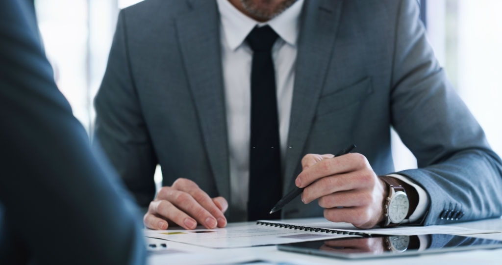 Closeup shot of two unrecognisable businesspeople going through paperwork together in an office